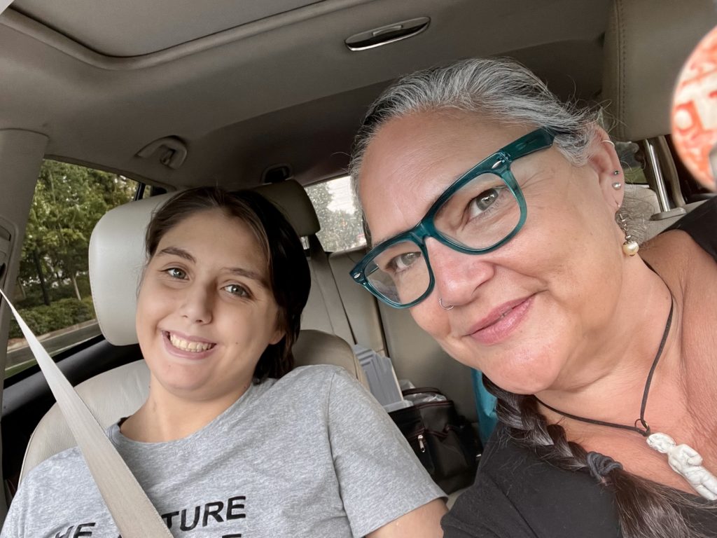 pciture of a young woman and her mohter in a car smiling